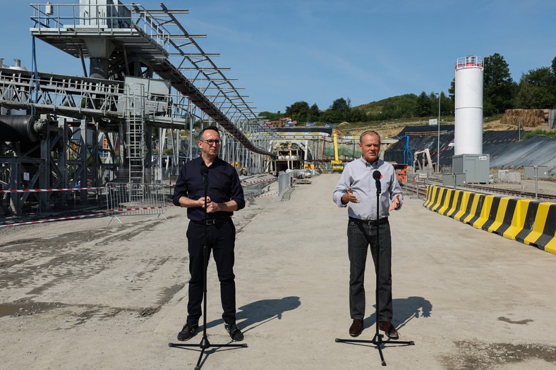 Męcina (woj. małopolskie), 07.08.2025. Premier Donald Tusk (P) i minister infrastruktury Dariusz Klimczak (L) na konferencji prasowej w Męcinie, 7 bm. Politycy odwiedzili budowę największego tunelu kolejowego w Polsce. (ad) PAP/Grzegorz Momot