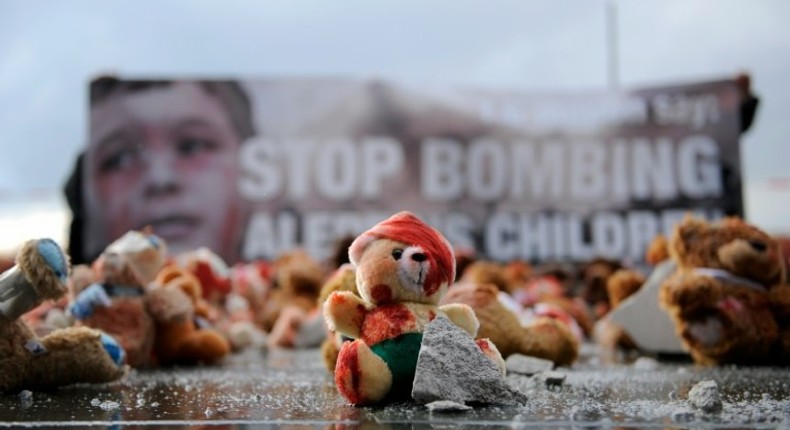 Colour-smeared teddy bears are laid by campaign group Avaaz in Berlin to protest the bombing of Aleppo ahead of a meeting of leaders of Russia, France and Germany