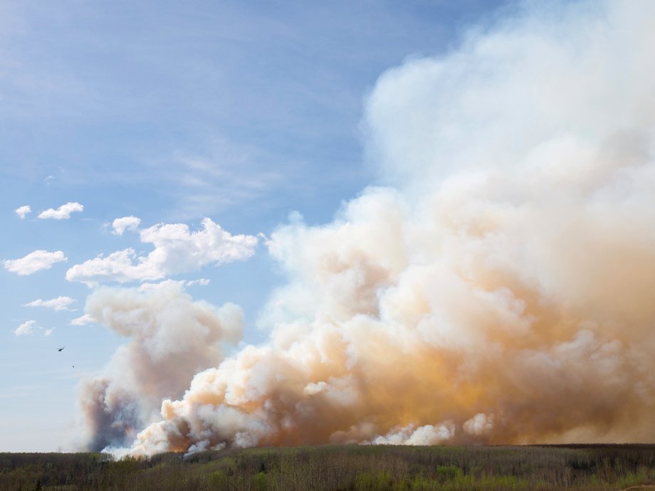 The smoke covers so much of the sky that it's hard to even see the helicopter here.