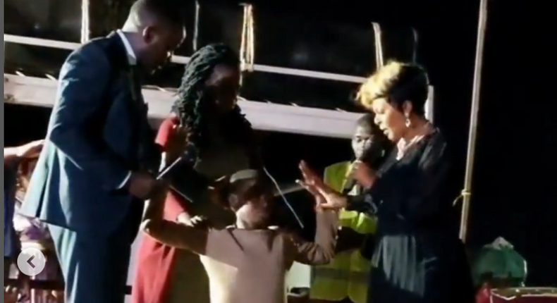A screen grab image of Size 8 casting out demons from a girl during a crusade in Kibwezi