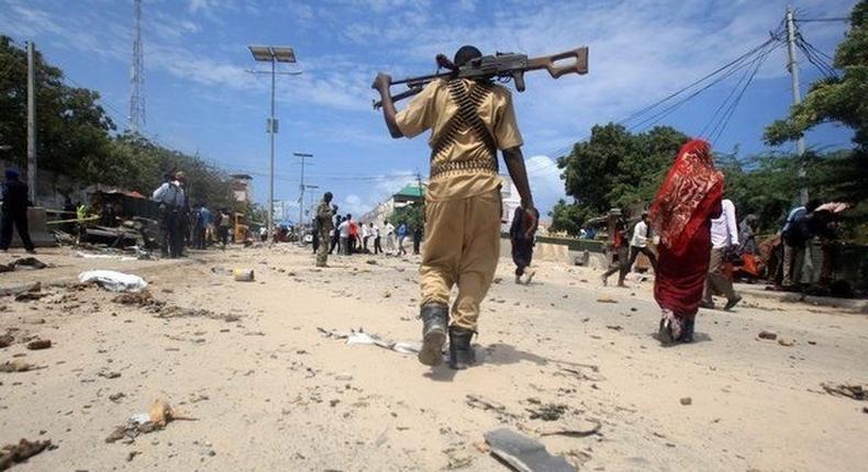 A Somali policeman walks towards the scene of an explosion outside the headquarters of Somalia's Criminal Investigation Department (CID) in the capital Mogadishu, July 31, 2016. 