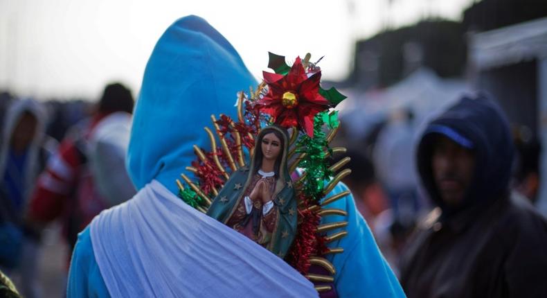 A pilgrim totes a statue of the Virgin of Guadalupe -- Mexico's City's patroness -- on his back