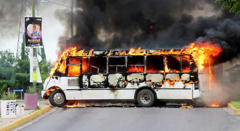 A burning bus, set alight by cartel gunmen to block a road, is pictured during clashes with federal forces following the detention of Ovidio Guzman, son of drug kingpin Joaquin
