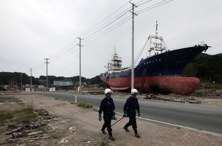 Policjanci obok statku zniszczonego przez tsunami po trzęsieniu ziemi 11 marca w Kesennuma City w Japonii. Zdjęcie z 10 września 2011 roku.