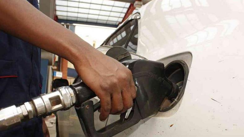 A petrol station attendant fuelling a car