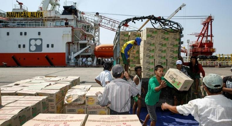 Myanmar workers load boxes of relief aid for Rohingya Muslims delivered by the humanitarian aid Malaysian ship Nautical Aliya in Yangon's Thilawa port on February 10, 2017
