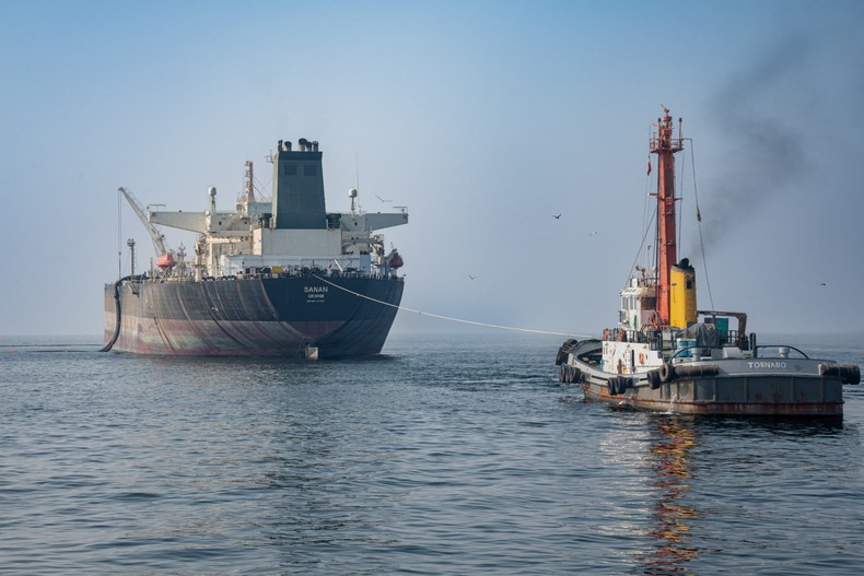 A tugboat is connected by a line to a crude oil tanker off the coast of Iran.Sam / Middle East Images / AFP via Getty Images