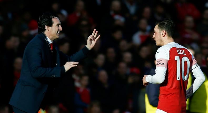 Arsenal manager Unai Emery talks with German midfielder Mesut Ozil