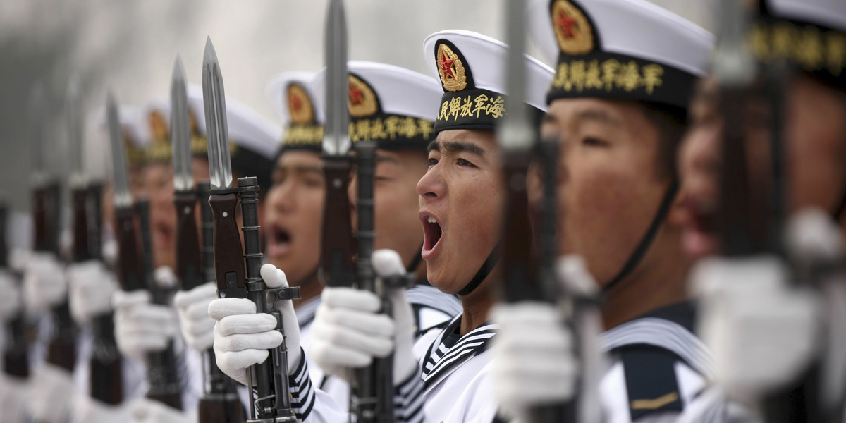 Chinese People's Liberation Army Navy recruits chant slogan during a parade to mark the end of a semester at a military base of the North Sea Fleet, in Qingdao, Shandong province, December 5, 2013.