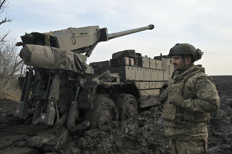 Ukraiński żołnierz stoi obok samobieżnej haubicy na linii frontu na południu Ukrainy, 14 lutego 2024 r.