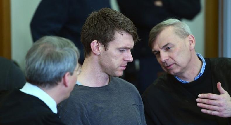 German far-right politician Maik Schneider (centre) talks to his lawyers during his trial in Potsdam, on February 9, 2017