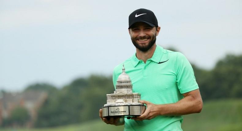 Kyle Stanley of the US celebrates with the winner's trophy after defeating compatriot Charles Howell in a playoff of the PGA National, in Potomac, Maryland, on July 2, 2017