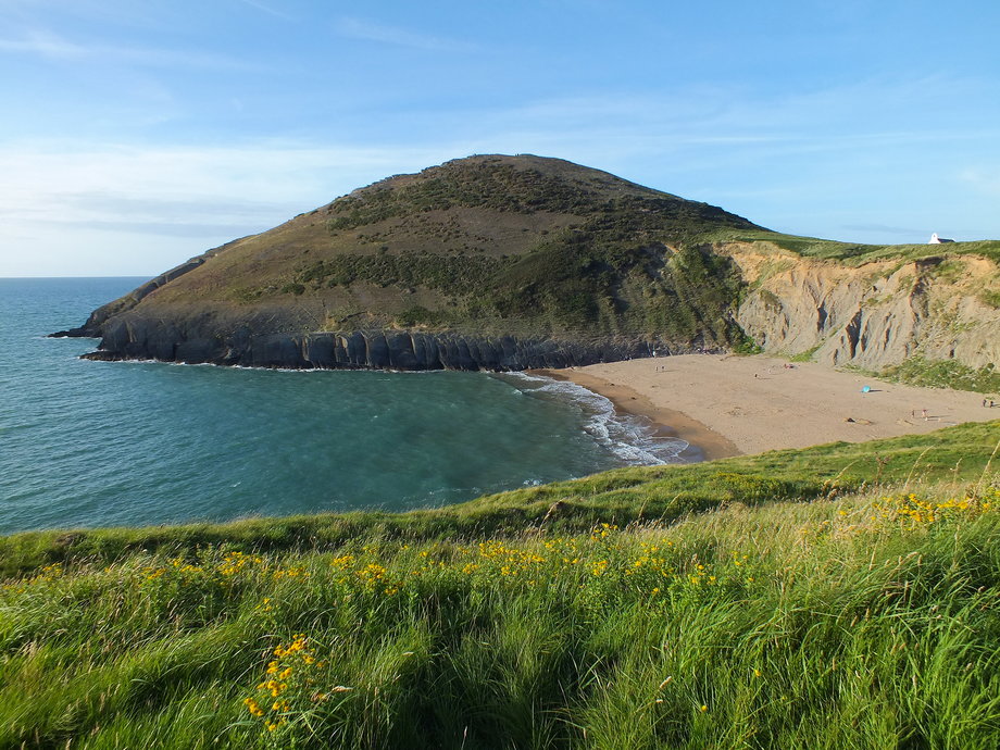 The sheltered cove of Mwnt, which is owned by the National Trust, is a popular off-the-beaten-track beach in Wales. Parking is available above the beach, with steps leading down to the tranquil setting. Plus, there's a path that circles to the top of the hill, where you can catch incredible views.