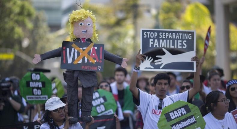 A woman carries a pinata based on Donald Trump during one of several May Day marches in Los Angeles, California