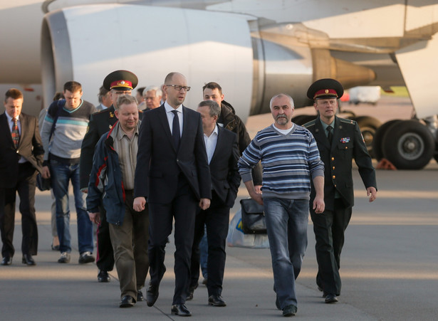 Arsenij JAceniuk i uwolnieni obserwatorzy OBWE na lotnisku w Kijowie. Fot. EPA/SERGEY DOLZHENKO