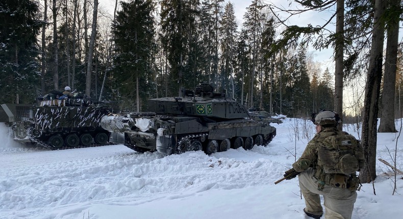 A soldier kneels in the snow in the forest next to a British Challenger 2 main battle tank (front) during a NATO exercise in Estonia.Alexander Welscher/picture alliance via Getty Images