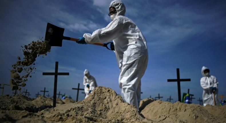 Members of the Rio de Paz NGO dig mock graves on Copacabana Beach on June 11