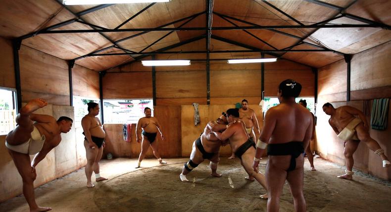 Mongolian-born Tomozuna Oyakata, or master of the Tomozuna stable, left, at his wrestlers' training session.