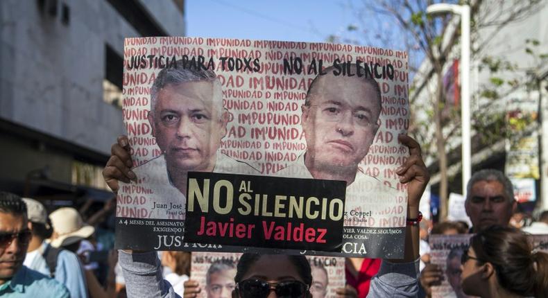 A woman holds a sign reading, Justice for all. No to silence as journalists, friends and relatives pay tribute to slain Mexican journalist Javier Valdez in May 2018