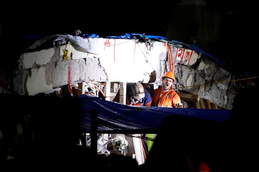 A rescue worker is helped during the search for students at Enrique Rebsamen school after an earthqu