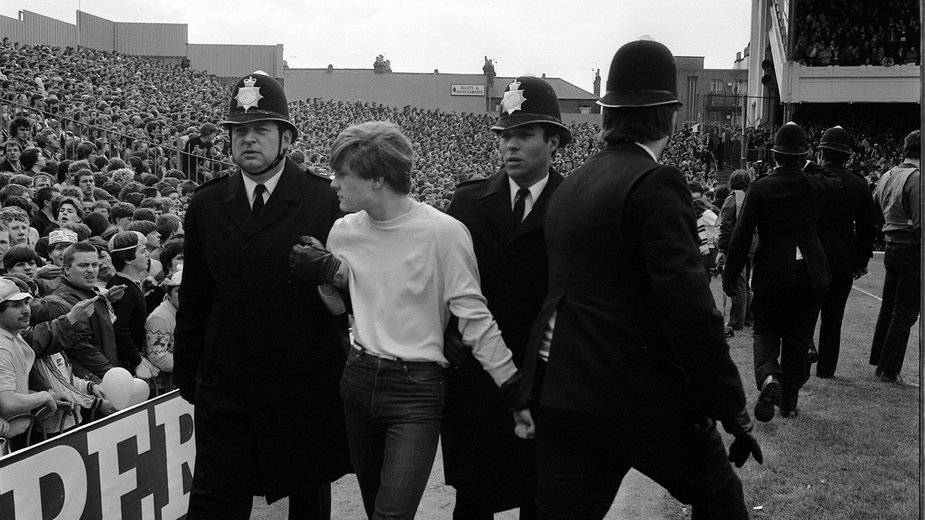 Kibic w eskorcie policji podcasz meczu (Arsenal - Aston Villa) na Highbury w Londynie w 1981 r.