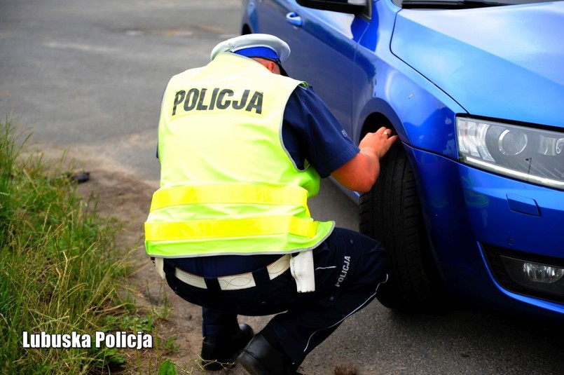 Policjant kontroluje stan opon