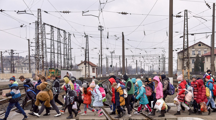 A dél-ukrajnai Hulaipole településen működő árvaházból kimenekített gyerekek mennek csomagjaikkal Lviv vasúti pályaudvarán 2022. március 7-én / Fotó: MTI/EPA/PAP/Vitalij Hrabar