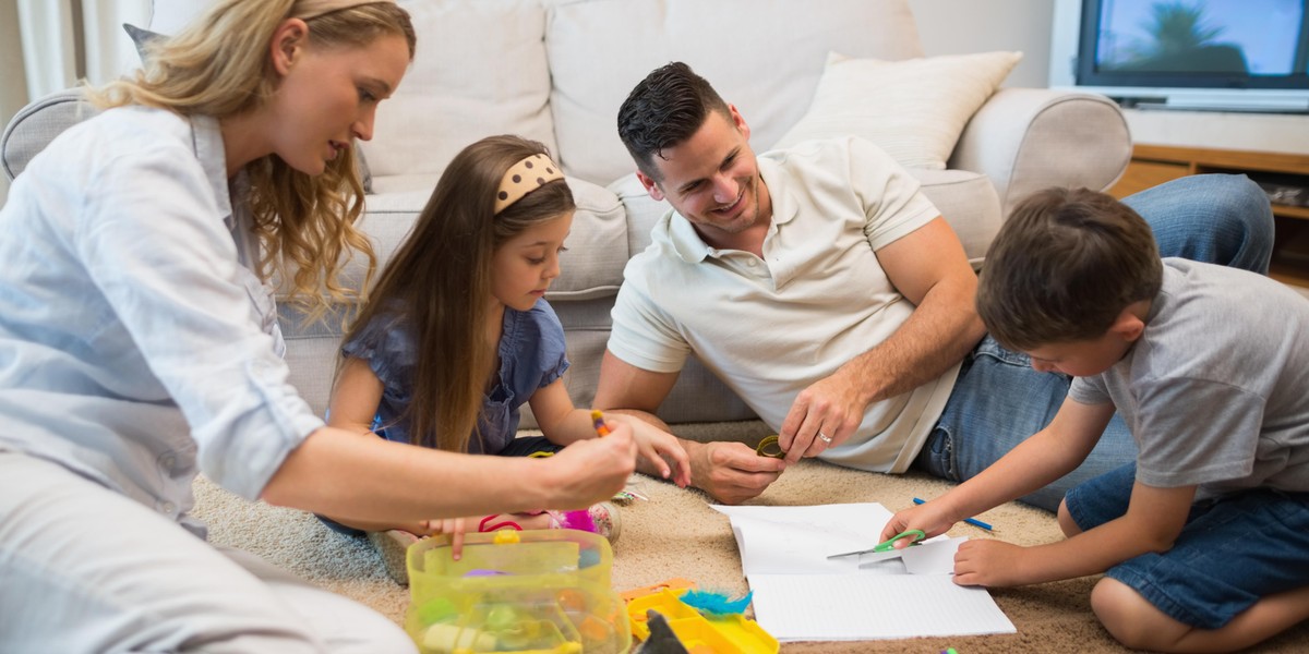 Family assisting boy in drawing at home