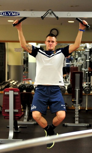 Piłkarz Pogoni Michał Janota podczas ćwiczeń na siłowni