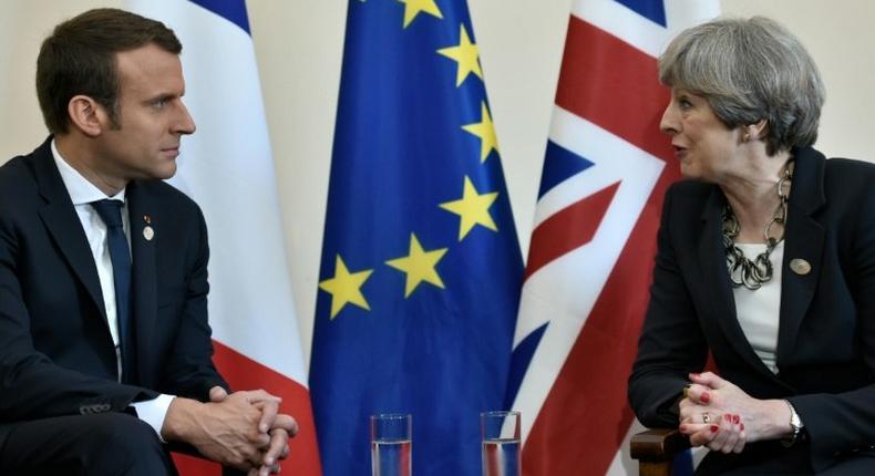 Britain's Prime Minister Theresa May and French President Emmanuel Macron talk on the sidelines of the G7 summit in Taormina, Italy, on May 26, 2017