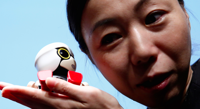 A staff member listens to Toyota Motor Corp's Kirobo Mini robot.