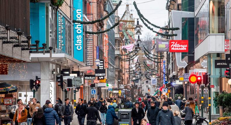 People stroll at the Drottninggatan shopping street in central Stockholm on November 10, 2020. Sweden is yet to implement a national lockdown amid the pandemic.