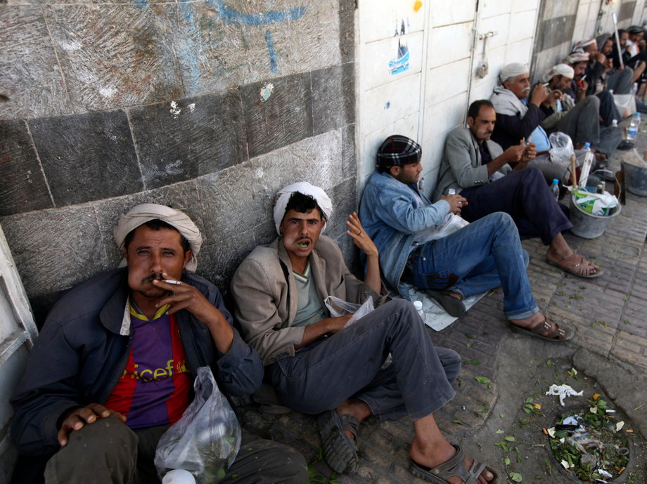Men wait to be hired for their labor along a main street in Sanaa, Yemen.