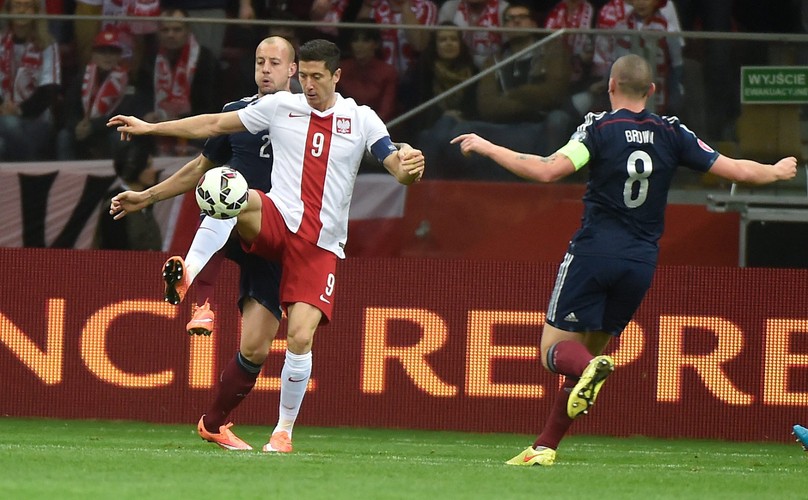 Polak Arkadiusz Milik (L) fetuje z Arturem Jędrzejczykiem (P) strzelenie bramki drużynie Szkocji na 2-2 podczas meczu eliminacyjnego piłkarskich mistrzostw Europy