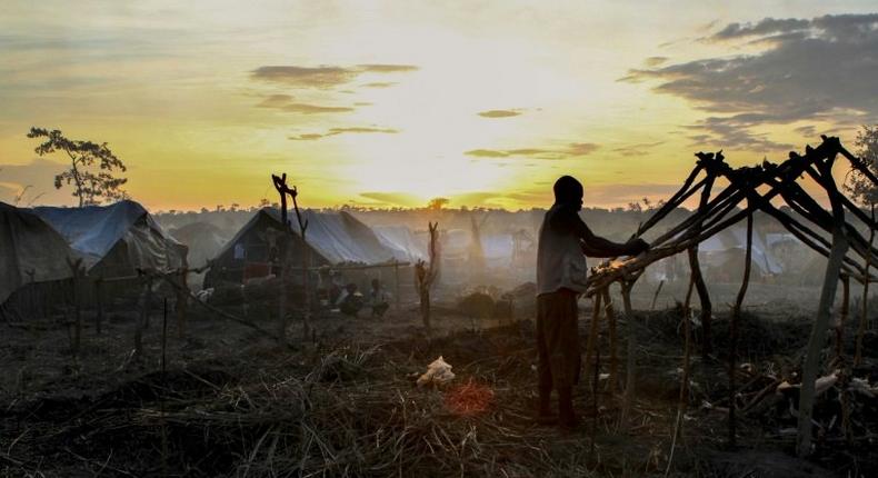 A man builds a tent at sunset in a camp for internally displaced people in Kaga Bandoro, Central African Republic