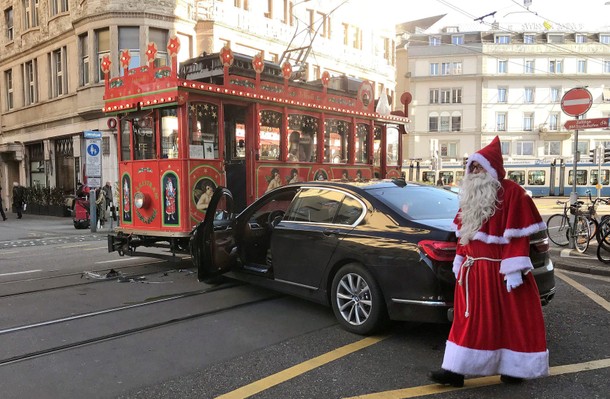 Driver of a Maerlitram (fairy tram), dressed as a Santa Claus, walks past a car which crashed into t