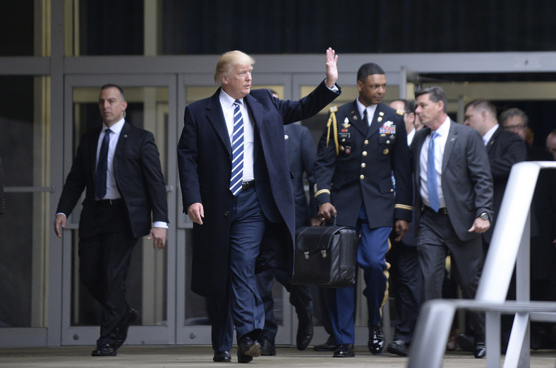 Były prezydent USA Donald Trump. Za nim wojskowy z "futbolówką"