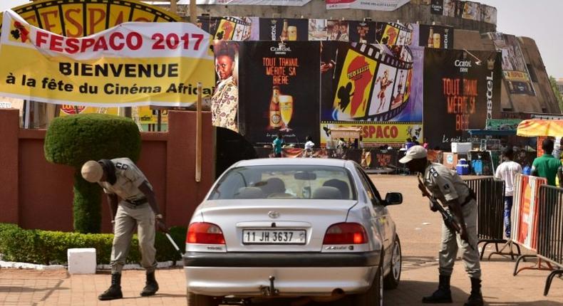 Police officers check cars at the entrance to the Pan-African Film and Television Festival (FESPACO) in Ouagadougou