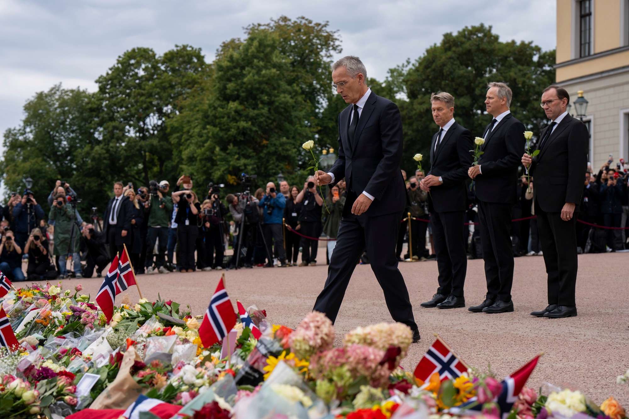  Nórsky minister financií Jens Stoltenberg kladie kvety na námestí pred kráľovským palácom v Osle.