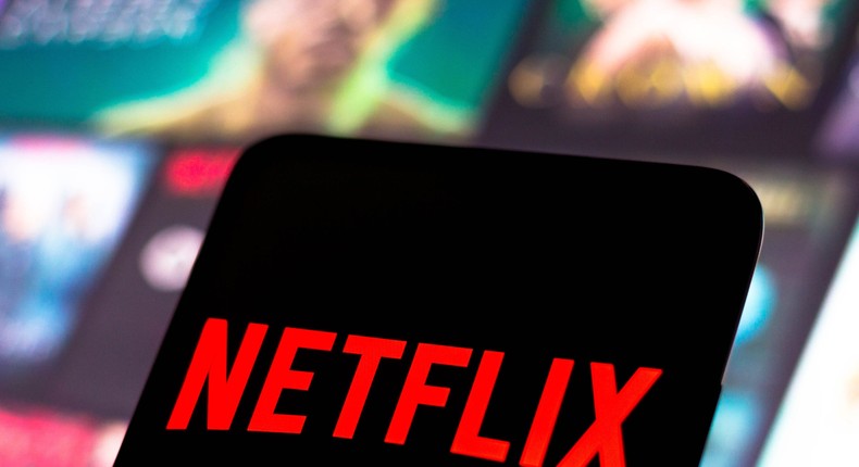 The Netflix logo is displayed on a smartphone screen.