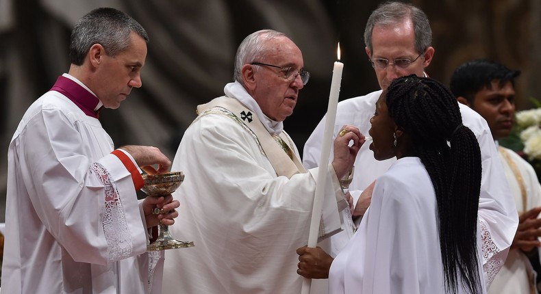 Pope Francis gives holy communion during the Easter vigil at St Peter’s basilica in the Vatican.Photograph: Alberto Pizzoli/AFP/Getty Images