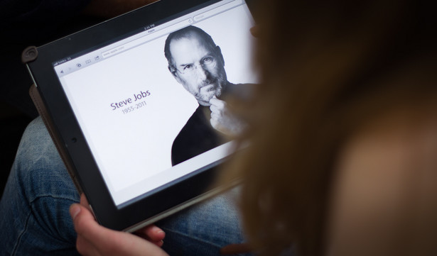 Kobieta ogląda na iPadzie hołd dla Steve'a Jobsa, Sydney, fot. Ian Waldie/Bloomberg