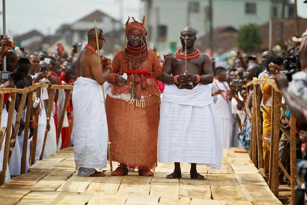 Newly crowned Oba of Benin Kingdom Eheneden Erediauwa is guided through a symbolic bridge by the pal