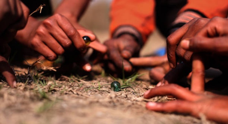 Kids playing 'bano' (marbles)