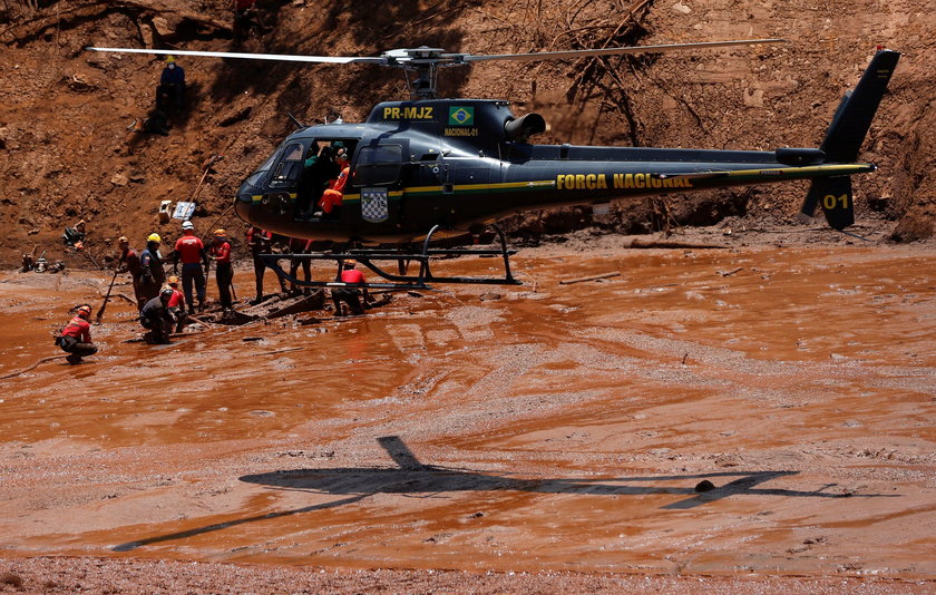 Members of a rescue team carry a body recovered after a tailings dam owned by Brazilian mining compa