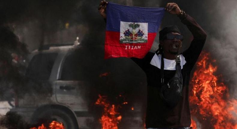 A demonstrator holds up a Haitian flag during protests demanding the resignation of Prime Minister Ariel Henry in Port-au-Prince, Haiti, March 1, 2024 [AP}