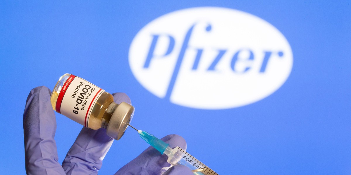 FILE PHOTO: A woman holds a small bottle labeled with a "Coronavirus COVID-19 Vaccine" sticker and a