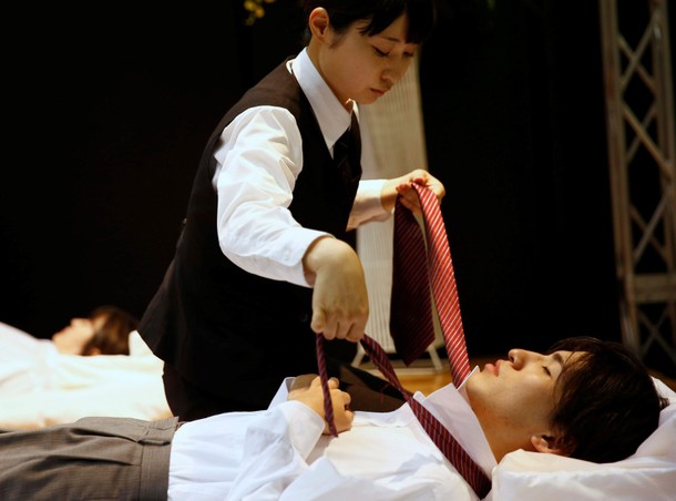 A funeral undertaker dresses a model during an encoffinment competition at Life Ending Industry EXPO