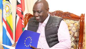 President William Ruto reading a document presented by officials from the EU