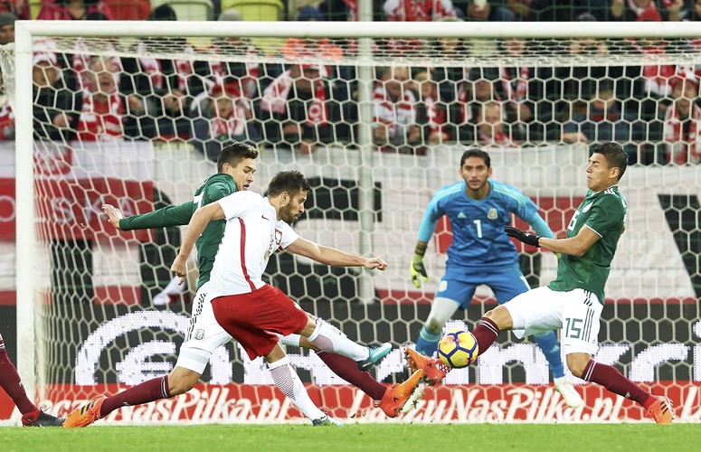 Maciej Makuszewski (2L) strzela na bramkę Jose de Jesusa Corony (w głębi)